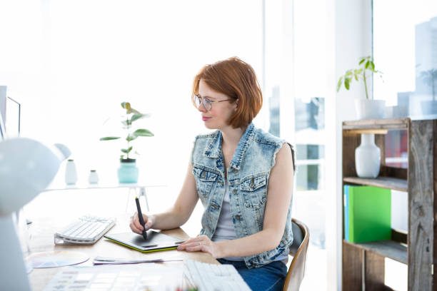 istock smiling hipster businesswoman writing on a digital drawing tablet 700818590