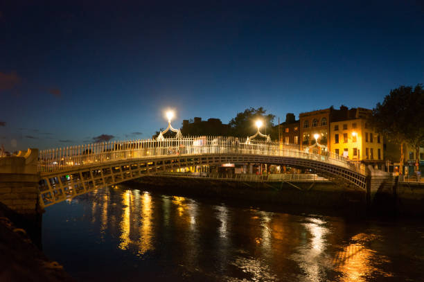 istock Illuminated Ha Penny Bridge Over Liffey River At Dusk 700824859