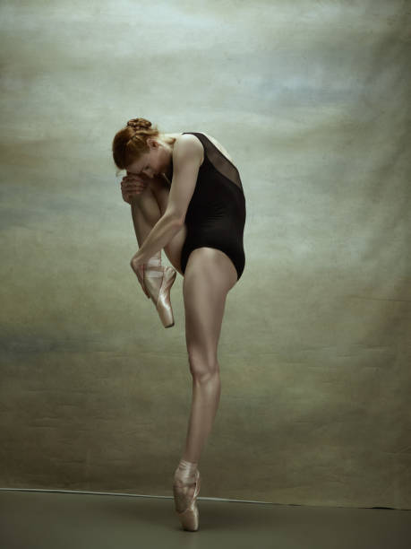 istock Ballerina posing in pointe shoes at gray pavilion 700828266