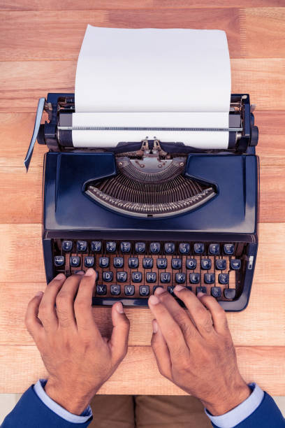 istock Businessman typing on typewriter at wooden desk 700828718