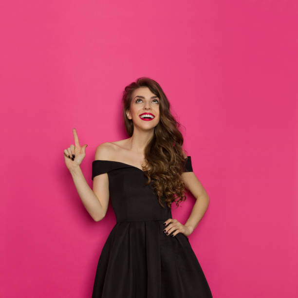 istock Elegant Smiling Woman Is Looking Up And Pointing 700828738