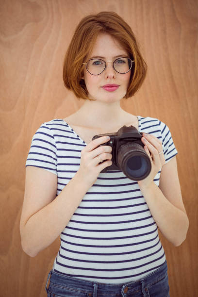 istock smiling hipster woman holding a digital camera 700839904