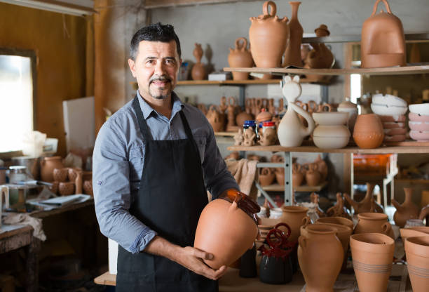 istock man potter holding ceramic vessels in atelier 700840222