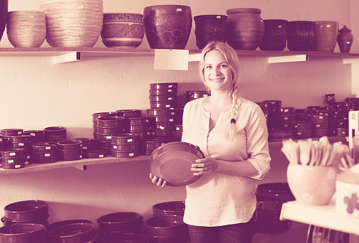 female customer choosing ceramics in ceramics workshop