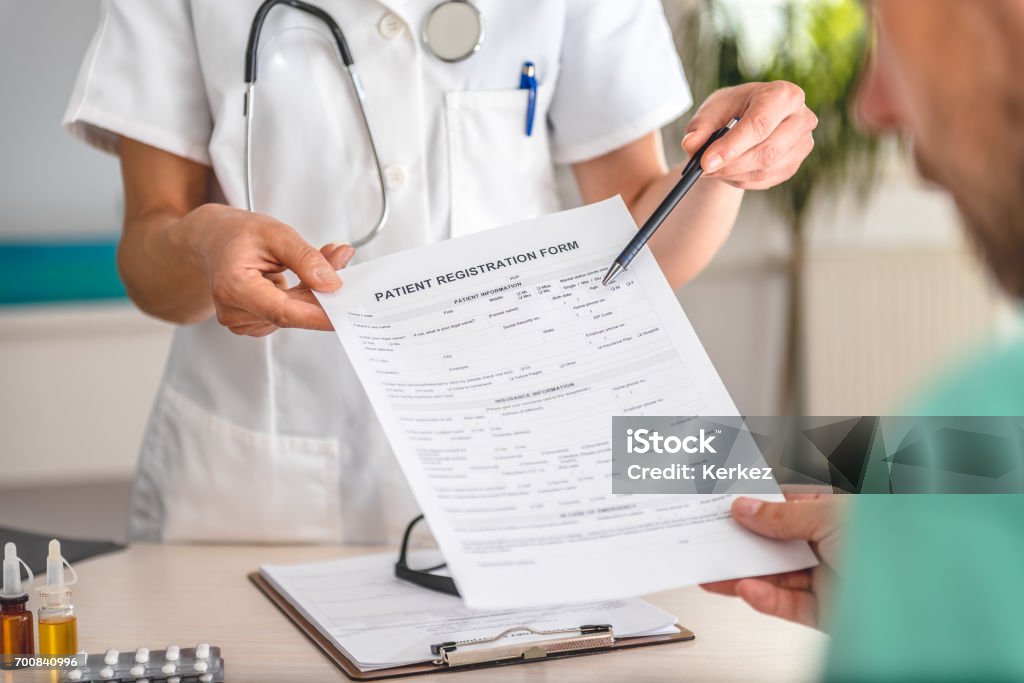 Médico recibe formulario registro de pacientes - Foto de stock de Paciente libre de derechos