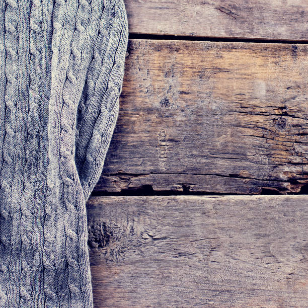 istock knitted plaid, sweater on old wooden boards 700866630