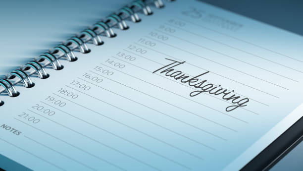 Calendar Concept Closeup of a personal calendar setting an important date representing a time schedule. Thanksgiving written on a white notebook to remind you an important appointment. thanksgiving holiday hours stock pictures, royalty-free photos & images