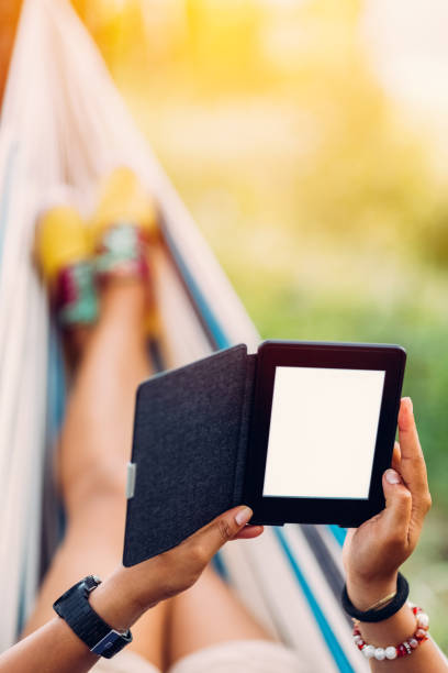 istock Relaxed girl in hammock reading an e-book 700875770