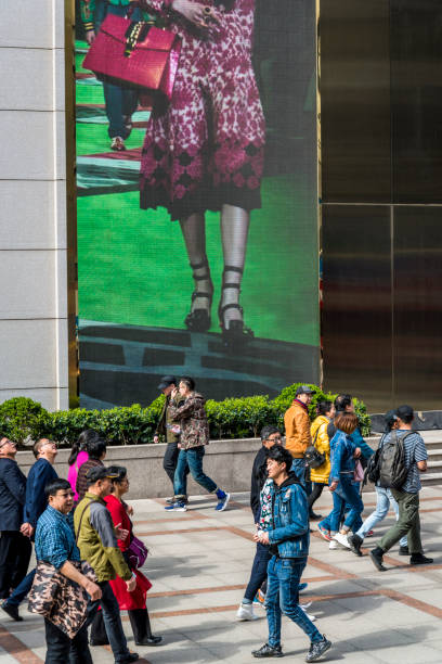 nanjing road (est), shanghai, cina - urban scene business sign large group of people foto e immagini stock