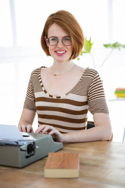 istock smiling hipster woman typing on her typewriter 700877778