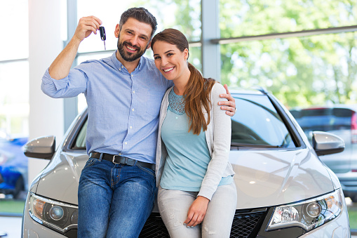 Young couple in the showroom, choosing a car