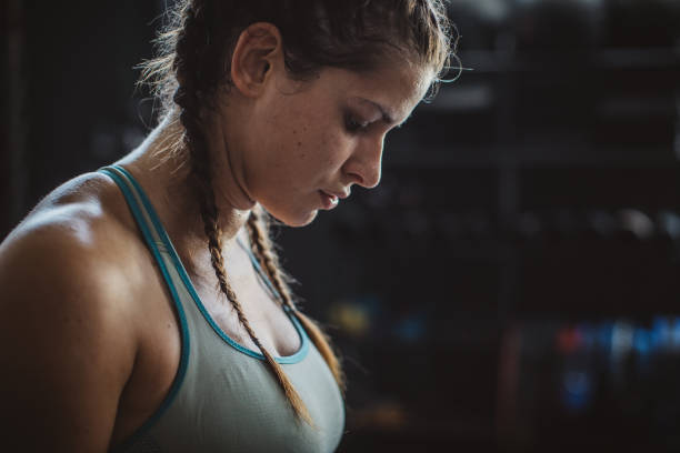 Close-up portrait of tired woman in gym, after cross training
