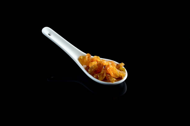 istock Raisin in white spoon over black background 700927598