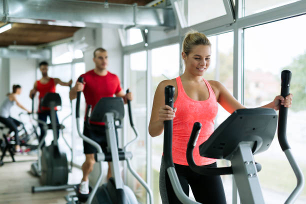 istock People doing on elliptical trainer in gym 700948714
