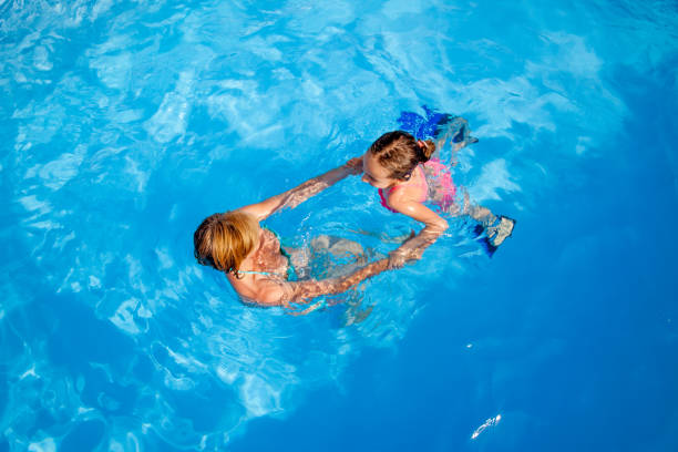 istock Mother Teaching Daughter How To Swim 700954634