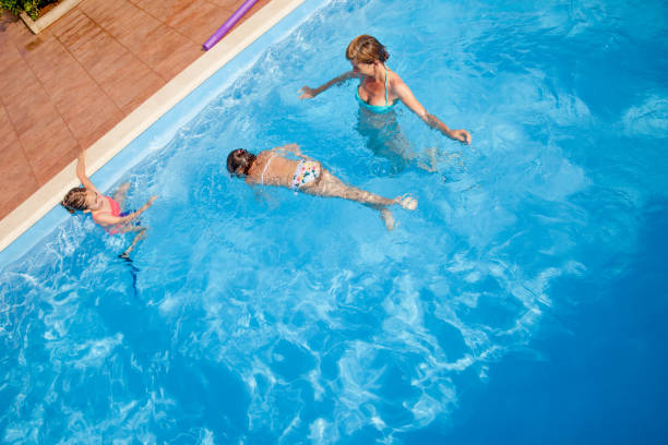 istock Single Mother Enjoy In The Swimming Pool With Daughters 700955076