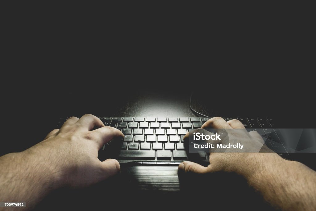 Manos en la oscura digitar en el teclado. Espacio de copia negro - Foto de stock de Embrujado libre de derechos