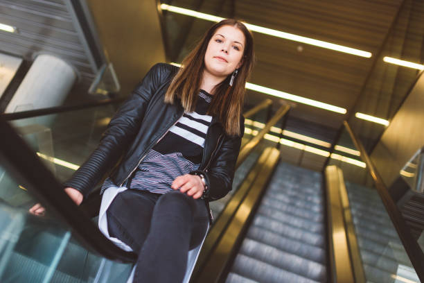 istock Teenager sitting on an escalator 700977392