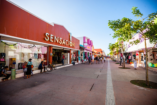 Cozumel, Mexico - December 29, 2016: Colorful shopping street in Cozumel with tourists shopping, sightseeing  and eating in sidewalk cafes.