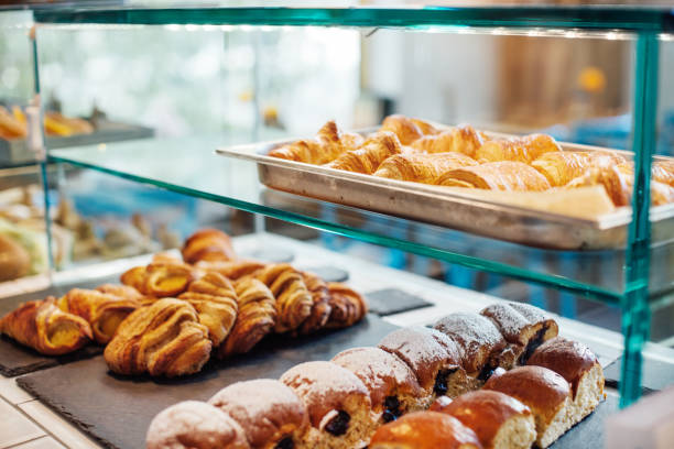 Freshly baked food in display cabinet at cafe Close-up of various baked food in glass cabinet. View of fresh snacks displayed for sale. It is in coffee shop. display cabinet photos stock pictures, royalty-free photos & images