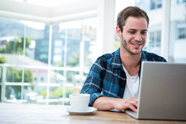 istock Handsome man working on laptop with cup of coffee 701032226