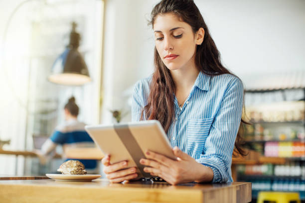 istock Beautiful woman using digital tablet in cafe 701038494