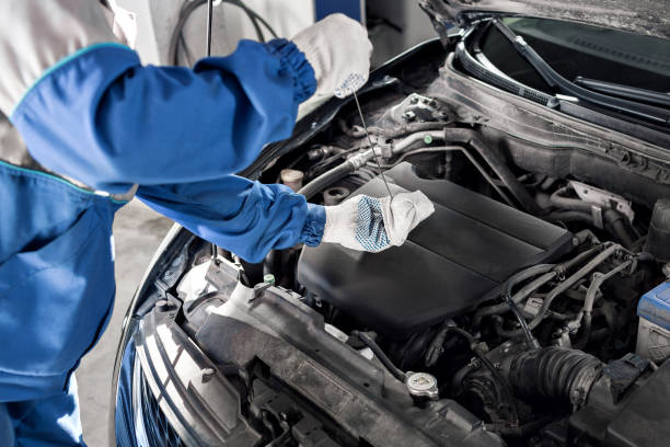 istock Mechanic checking oil level in a car workshop 701038882