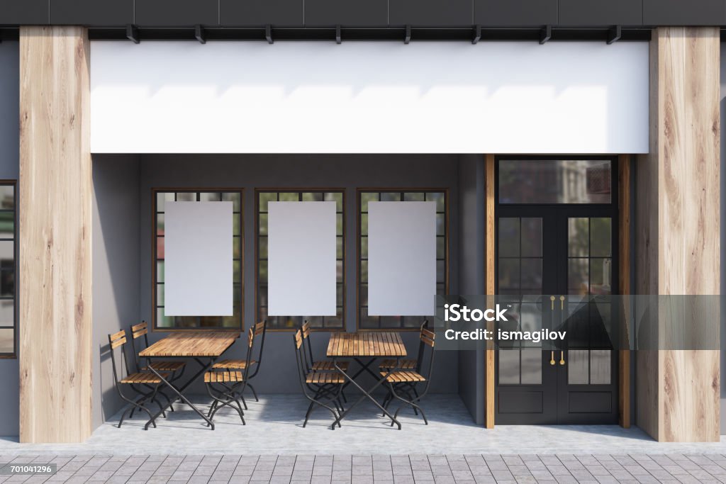 Gray cafe exterior, posters Exterior of a cafe with gray walls, three posters hanging on them and wooden tables with chairs. 3d rendering, mock up Restaurant Stock Photo