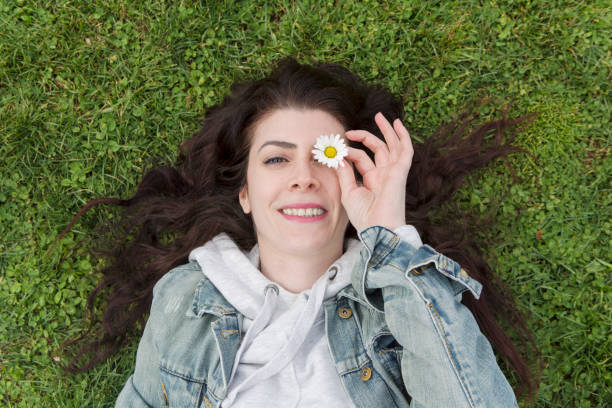 istock Smiling woman with daisy 701050122