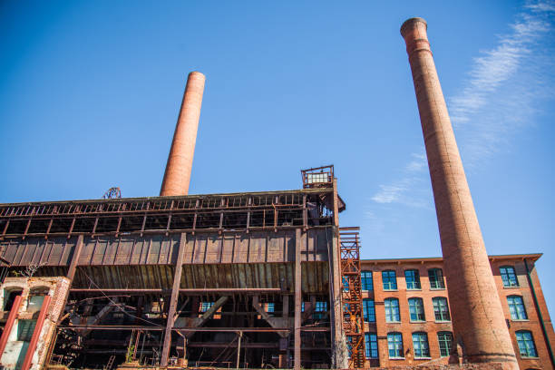 Close up photograph of the main building for a cotton mill ruin in Atlanta, GA that has been turned into urban residences. The two towering smokestacks are built of brick as is the rest of the structure.