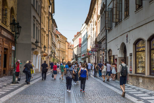 straßenszene von der prager altstadt mit ihrer architektur und menschen zu fuß auf der straße mit kopfsteinpflaster. - tourist day prague crowd stock-fotos und bilder