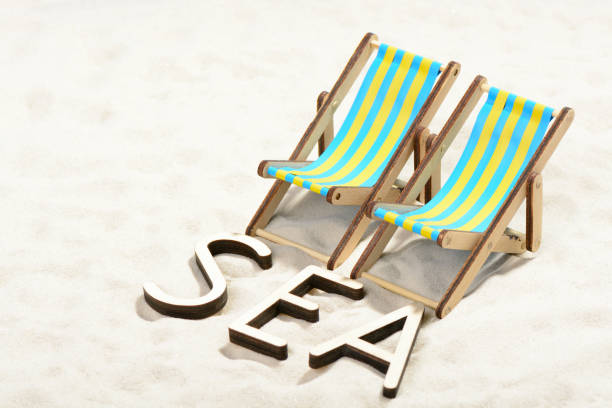 istock The word SEA and two sunbeds at the beach 701100768