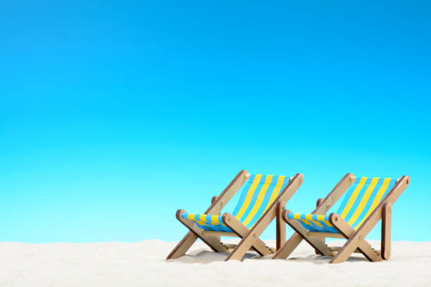 istock Two sunbeds at the beach on background of blue sky 701100786