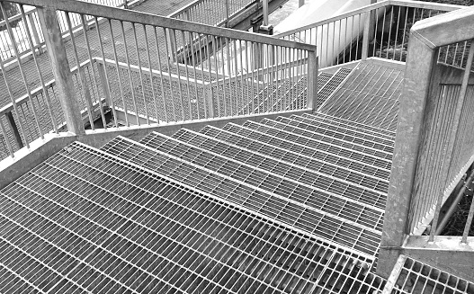 Metal staircase gray railing on concrete wall