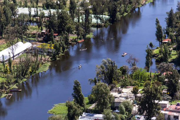 aerial view of mexican Xochimilco channel Mexico City, Mexico, march 16, 2015, aerial view of southern district Xochimilco, an important tourist attraction where little boats called chalupas navigate through the channels selling products and as transportation to agricultural chinampas or floating gardens trajinera stock pictures, royalty-free photos & images