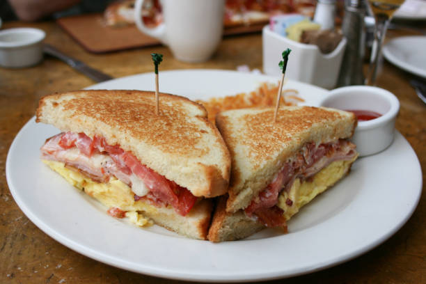 eiern, speck und käse frühstück sandwich mit hash brown kartoffeln - hash brown stock-fotos und bilder