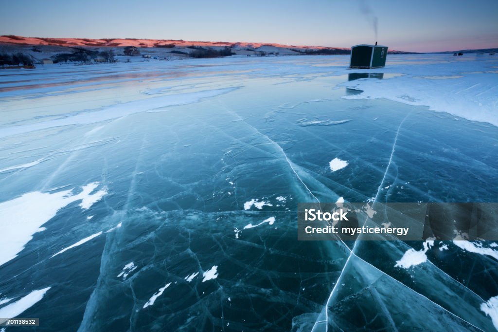 Buffalo Pound Provincial Park Ice Fishing Saskatchewan Near Moose Jaw Canada Ice fishing on Buffalo Pound Provincial Park, near Moose Jaw, Saskatchewan, Canada. Image taken from a tripod. Early morning image. Morning light just starting to set on the hills, first light. Ice Fishing Stock Photo