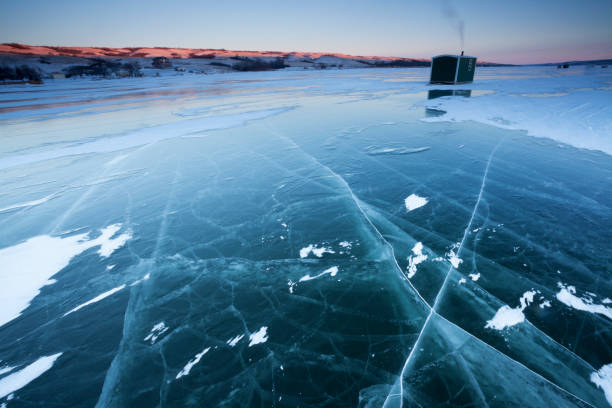 Buffalo Pound Provincial Park Ice Fishing Saskatchewan Near Moose Jaw Canada Ice fishing on Buffalo Pound Provincial Park, near Moose Jaw, Saskatchewan, Canada. Image taken from a tripod. Early morning image. Morning light just starting to set on the hills, first light. ice fishing stock pictures, royalty-free photos & images