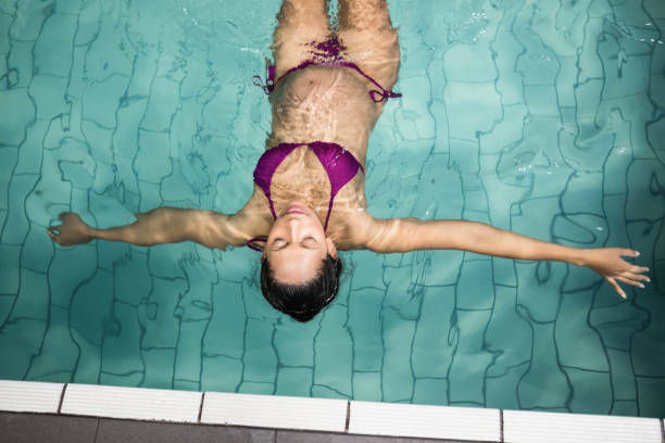 istock Pregnant woman floating in the pool 701138656