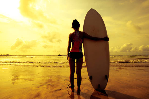 istock Young woman surfer with surfboard ready to surf 701143272