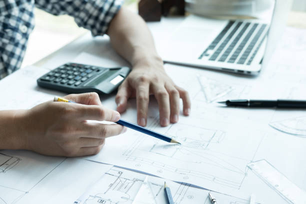 istock Architect working on real estate project at workplace. Male engineer hand working with living house blueprint at office. Business, people, construction and building concept 701152316