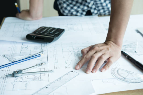 istock Architect working on real estate project at workplace. Male engineer hand working with living house blueprint at office. Business, people, construction and building concept 701152324