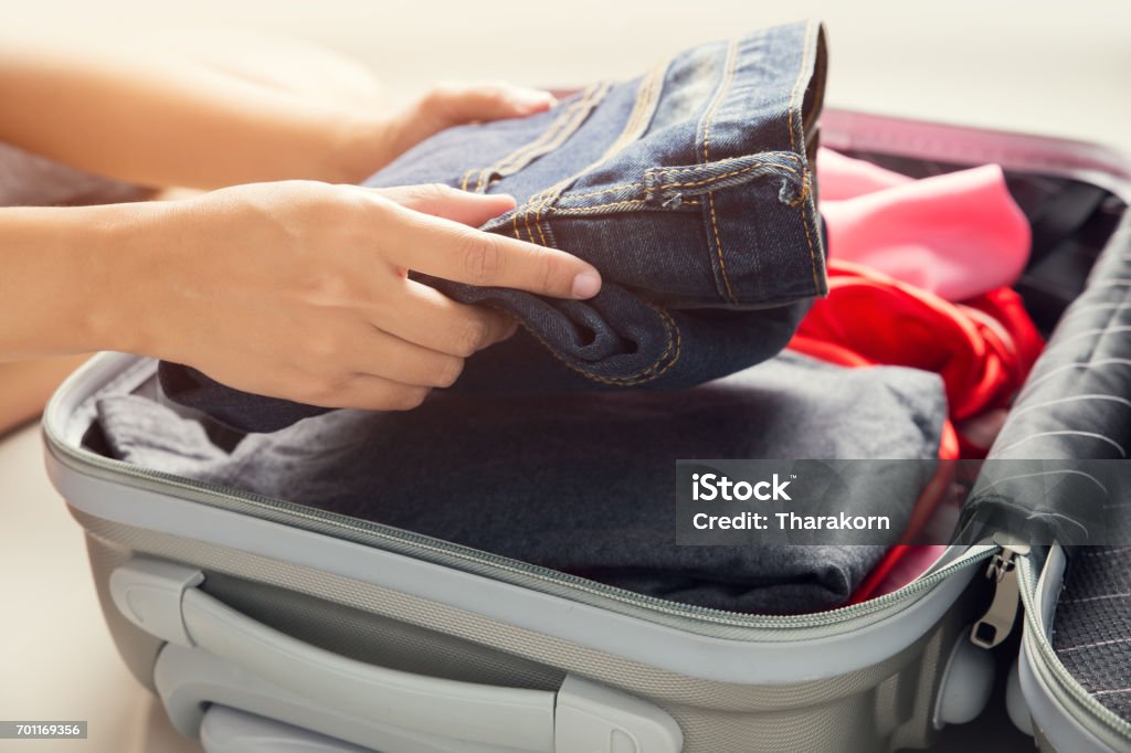 Close up of businesswoman packing clothes into travel bag - Luggage and people concept Carry-On Luggage Stock Photo