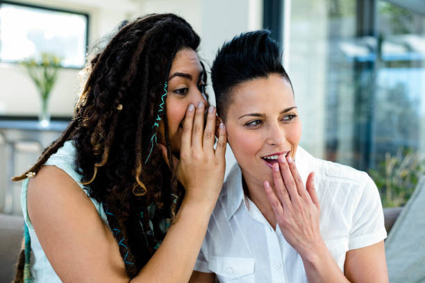 istock Lesbian couple whispering in ears 701181234