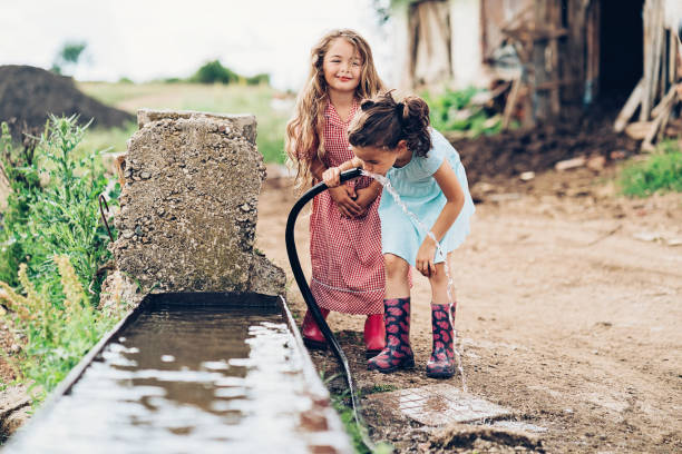 호스에서 작은 여자 식 수 - water drinking village rural scene 뉴스 사진 이미지