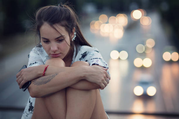 istock Girl sitting lonely and sad 701184516