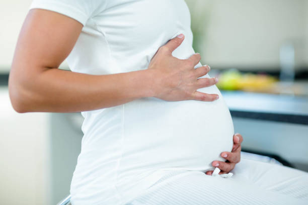istock Pregnant woman touching her belly 701211186