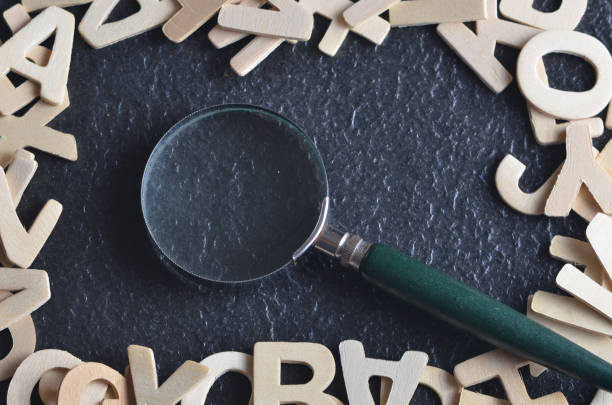 istock Magnifying glass with various alphabet on black background 701223084