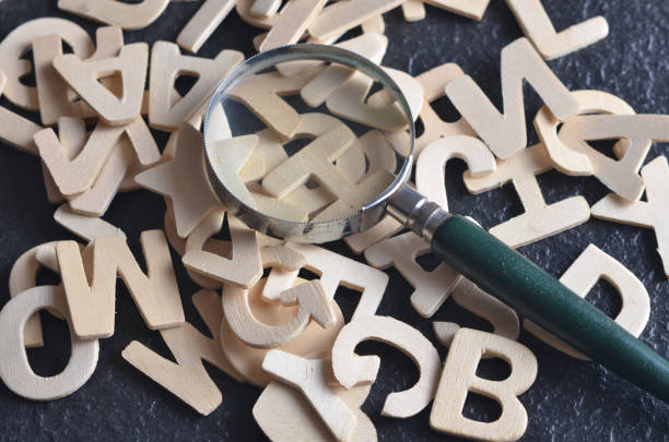 istock Magnifying glass with various alphabet on black background 701223092