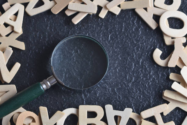 istock Magnifying glass with various alphabet on black background 701223126